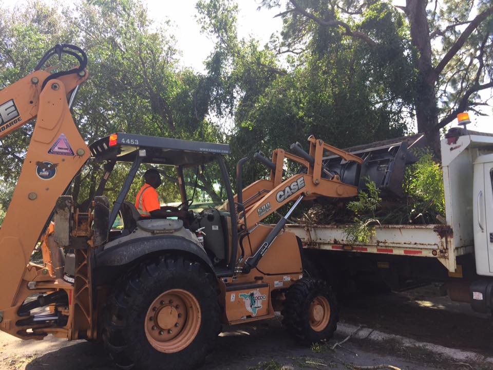 Cocoa Public Works employee on a piece of equipment removing tree debris following a storm